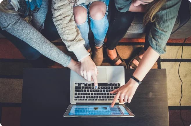 Students working together around a laptop